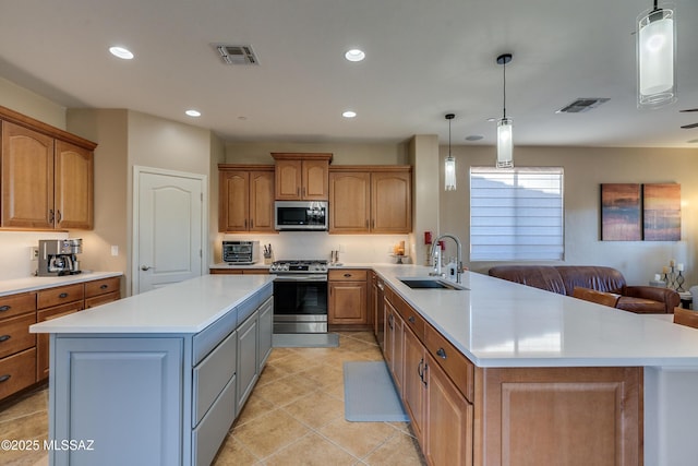 kitchen with a center island, stainless steel appliances, hanging light fixtures, and sink