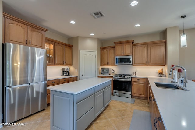 kitchen with appliances with stainless steel finishes, sink, decorative light fixtures, a center island, and gray cabinets