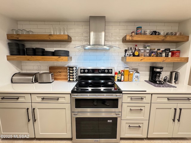 kitchen with decorative backsplash, double oven range, and exhaust hood