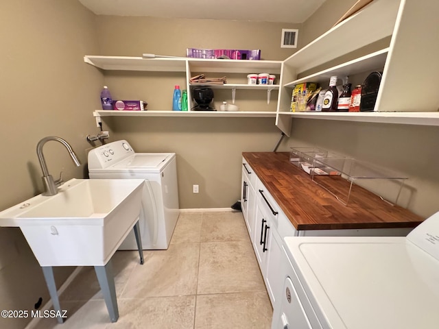 washroom with cabinets, independent washer and dryer, sink, and light tile patterned floors