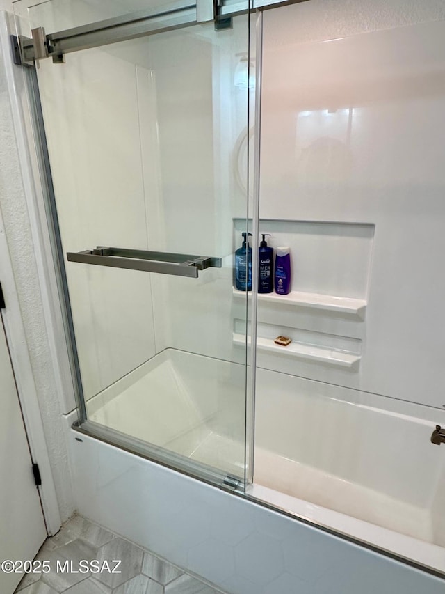 bathroom featuring tile patterned floors and combined bath / shower with glass door