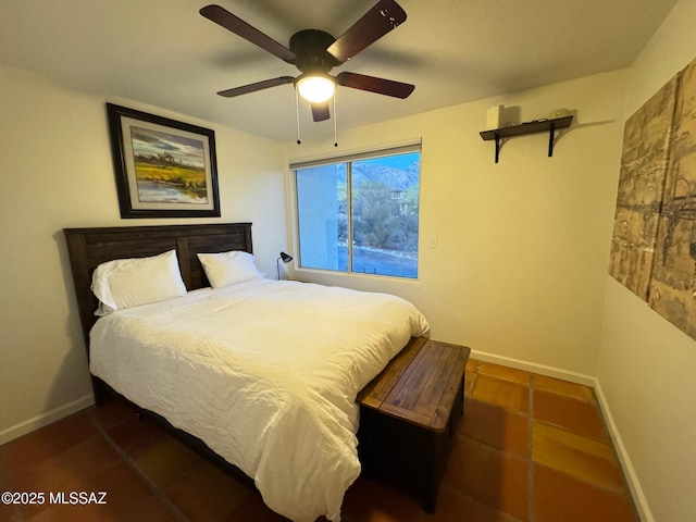 bedroom with ceiling fan and dark tile patterned floors