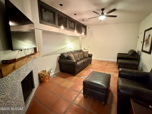 tiled living room with ceiling fan and a tiled fireplace