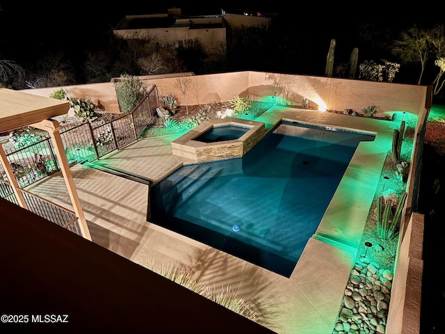 pool at night with an in ground hot tub