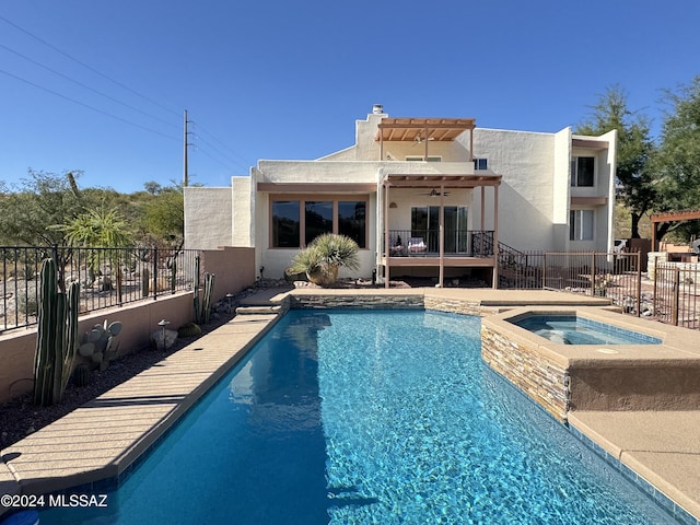 view of swimming pool with ceiling fan and an in ground hot tub