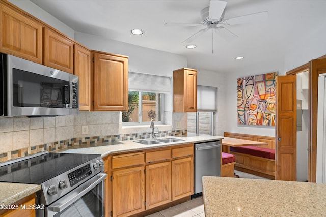 kitchen featuring sink, light tile patterned floors, ceiling fan, stainless steel appliances, and tasteful backsplash