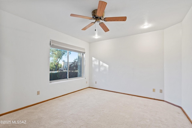 carpeted spare room with ceiling fan