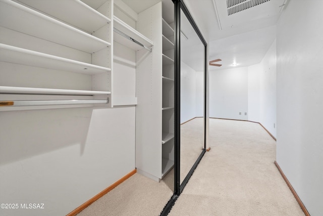 walk in closet featuring light carpet