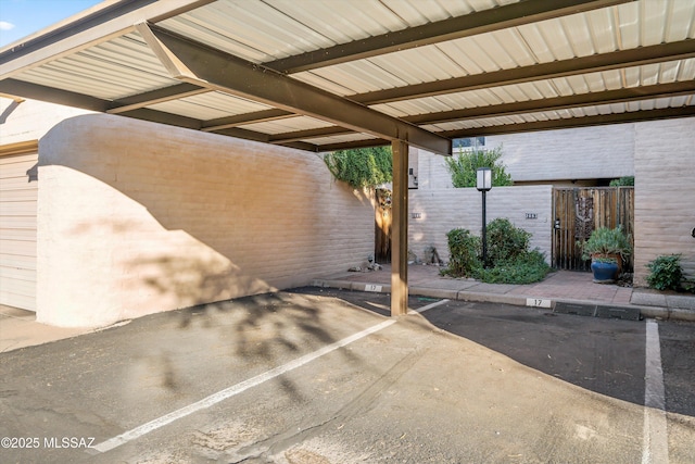 covered parking lot featuring fence