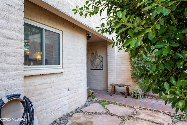 view of exterior entry with a patio area