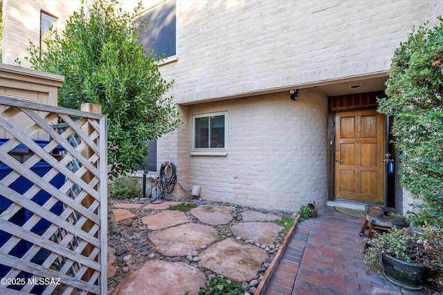 view of exterior entry with brick siding