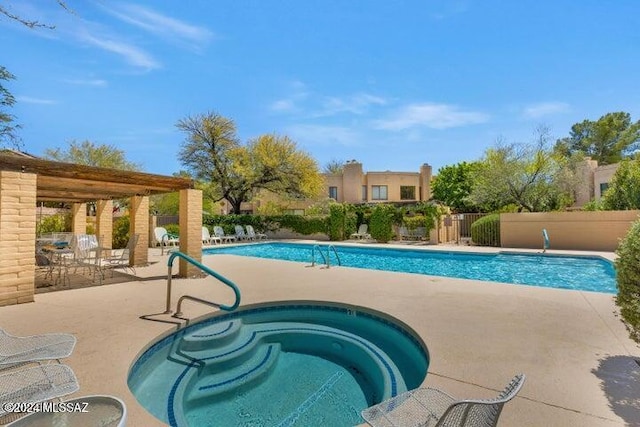 pool with a community hot tub, a patio area, and fence