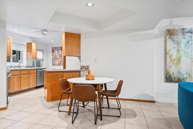 dining room with light tile patterned floors, a raised ceiling, and ceiling fan