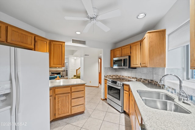 kitchen featuring sink, ceiling fan, backsplash, stainless steel appliances, and light tile patterned flooring