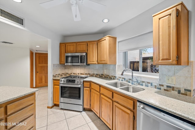 kitchen with sink, light tile patterned floors, decorative backsplash, and appliances with stainless steel finishes