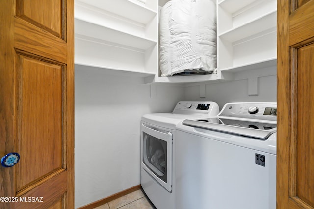 washroom with light tile patterned floors, laundry area, baseboards, and washer and dryer