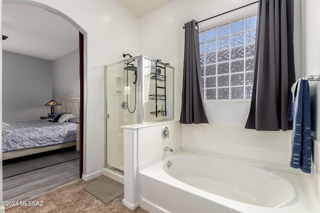 bathroom featuring tile patterned flooring and shower with separate bathtub