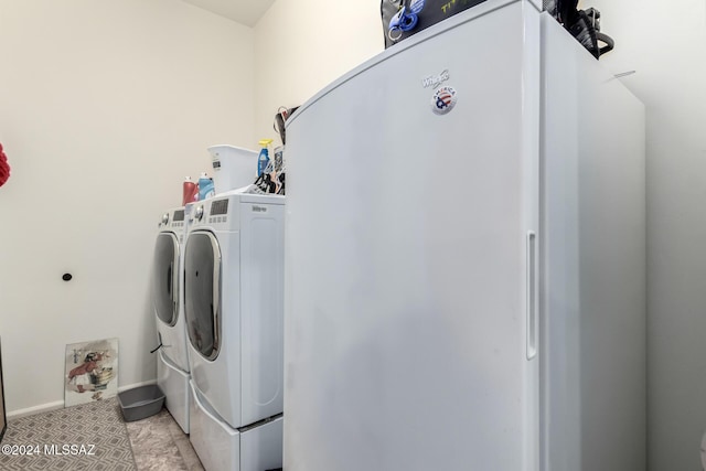 washroom with separate washer and dryer and light tile patterned flooring