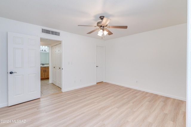 unfurnished room with ceiling fan, light wood-type flooring, and sink