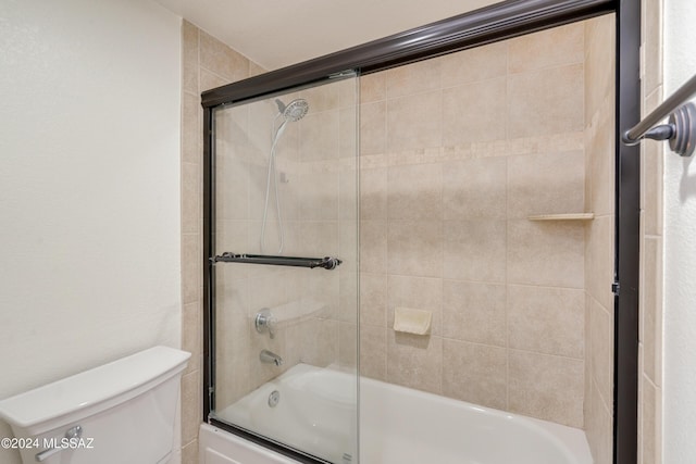 bathroom featuring shower / bath combination with glass door and toilet