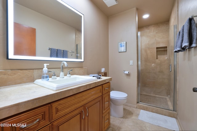 bathroom with tile patterned floors, vanity, toilet, and walk in shower