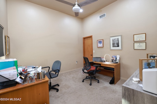 carpeted office with ceiling fan and high vaulted ceiling