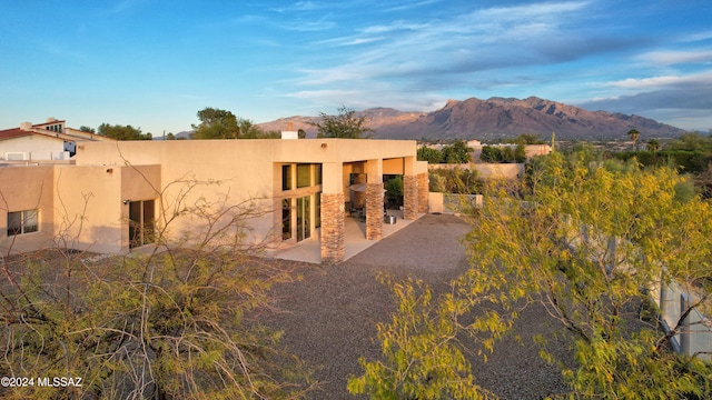 back of house featuring a mountain view and a patio