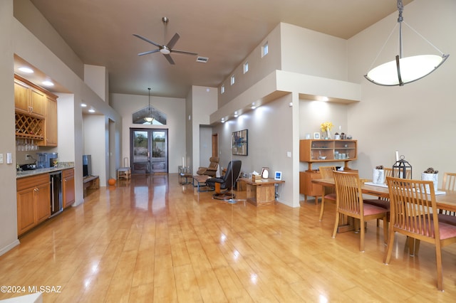 kitchen featuring high vaulted ceiling, french doors, hanging light fixtures, light hardwood / wood-style flooring, and ceiling fan