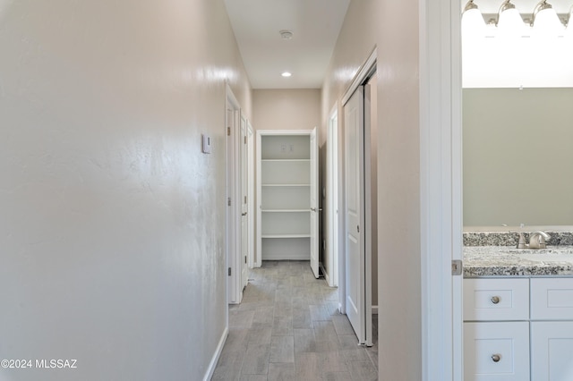 hallway with sink and light wood-type flooring