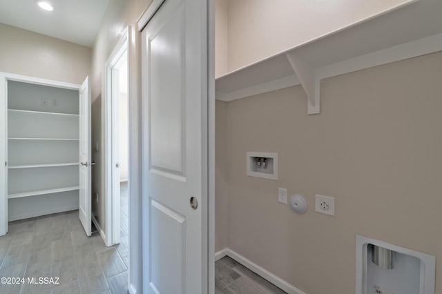 clothes washing area featuring electric dryer hookup, light hardwood / wood-style floors, gas dryer hookup, and hookup for a washing machine