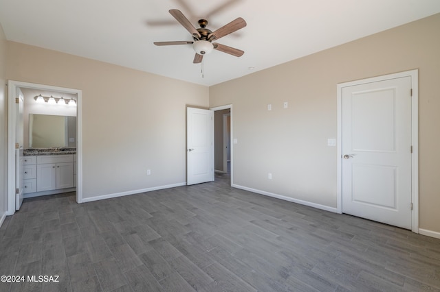 unfurnished bedroom with connected bathroom, ceiling fan, and wood-type flooring