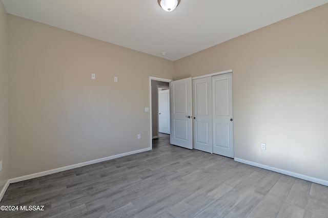 unfurnished bedroom featuring light hardwood / wood-style floors and a closet