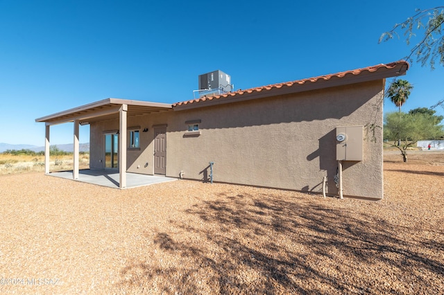 rear view of house featuring cooling unit and a patio