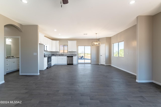 kitchen featuring dark wood-type flooring, hanging light fixtures, ceiling fan, appliances with stainless steel finishes, and white cabinetry