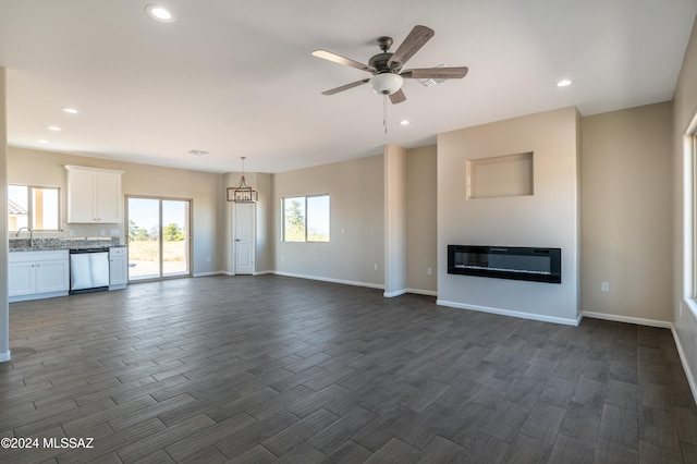 unfurnished living room with dark hardwood / wood-style flooring, ceiling fan, and sink