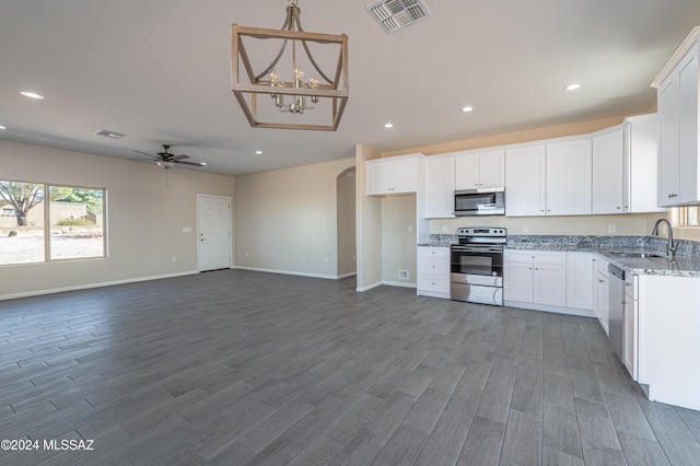 kitchen with light stone countertops, stainless steel appliances, sink, dark hardwood / wood-style floors, and white cabinetry