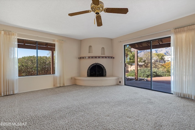 unfurnished living room with carpet floors and ceiling fan