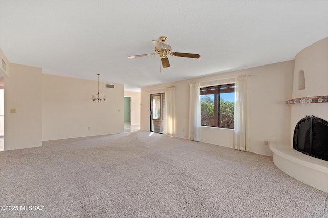 unfurnished living room with ceiling fan with notable chandelier and carpet