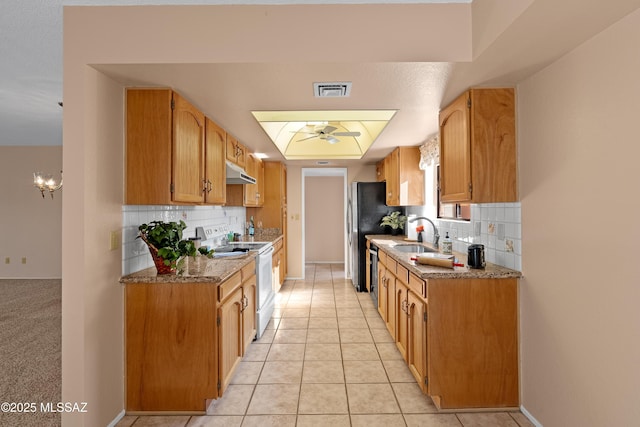 kitchen with electric range, dishwasher, light tile patterned floors, sink, and ceiling fan with notable chandelier