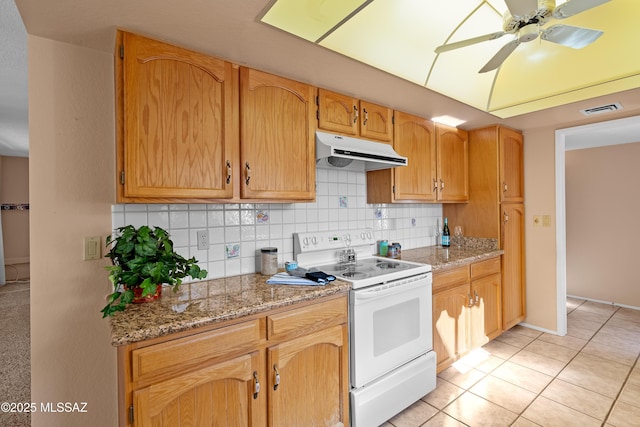 kitchen featuring white range with electric cooktop, decorative backsplash, light stone countertops, and light tile patterned floors