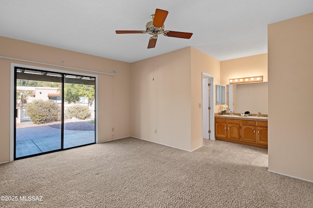 carpeted spare room with ceiling fan and sink