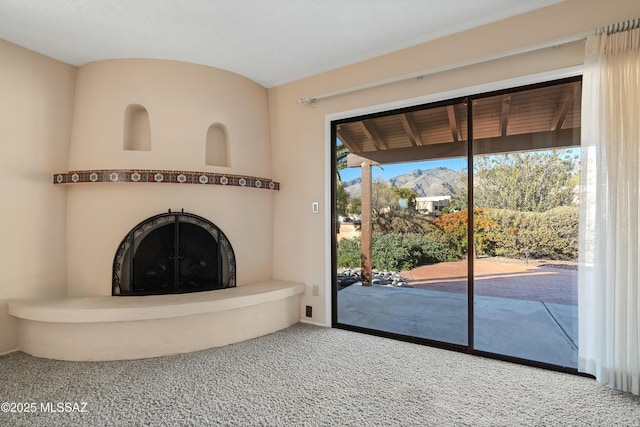 unfurnished living room featuring carpet and a mountain view