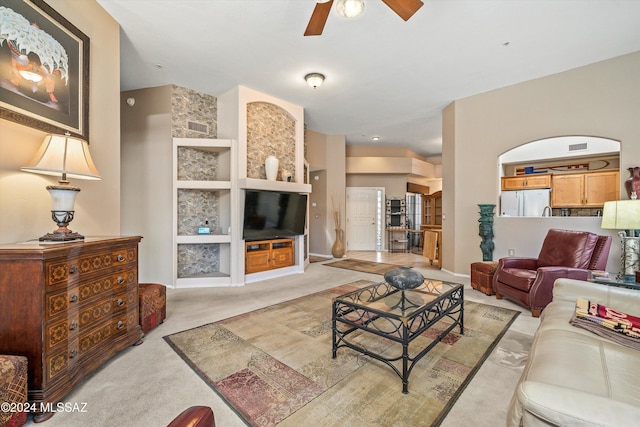 carpeted living room with ceiling fan