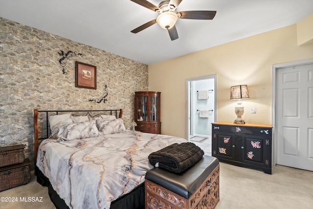 bedroom with ceiling fan, light carpet, and connected bathroom