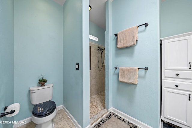 bathroom featuring tile patterned floors, toilet, and a tile shower