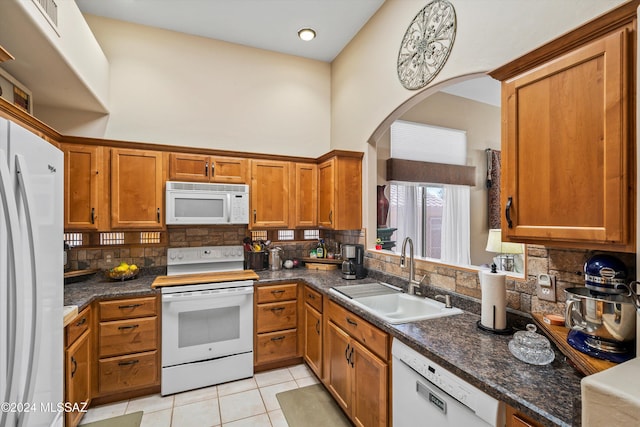 kitchen featuring white appliances, backsplash, and sink