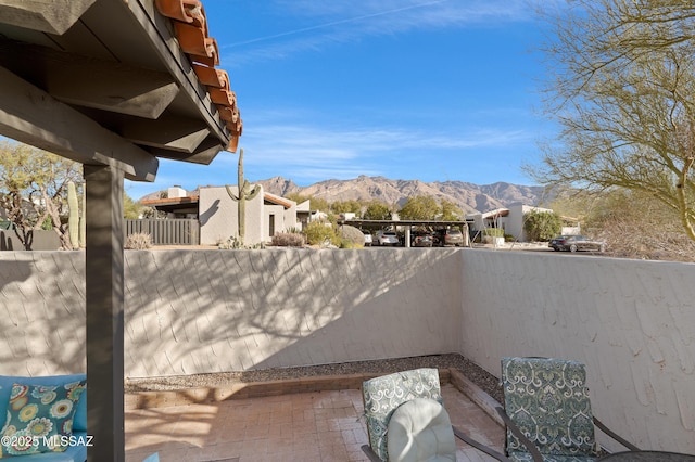 view of patio / terrace with fence and a mountain view