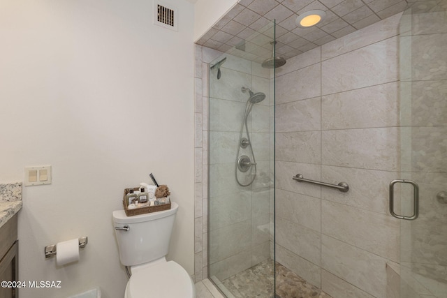 bathroom featuring vanity, an enclosed shower, and toilet