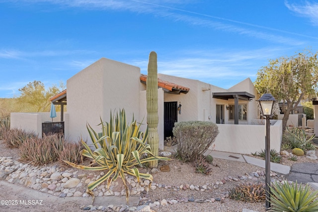 view of home's exterior featuring fence and stucco siding