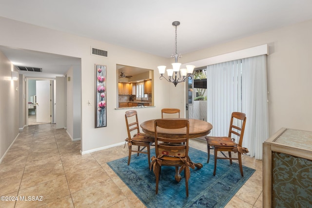 tiled dining area featuring ceiling fan with notable chandelier